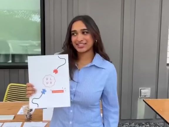 Holding up a FLUX flyer at a club fair